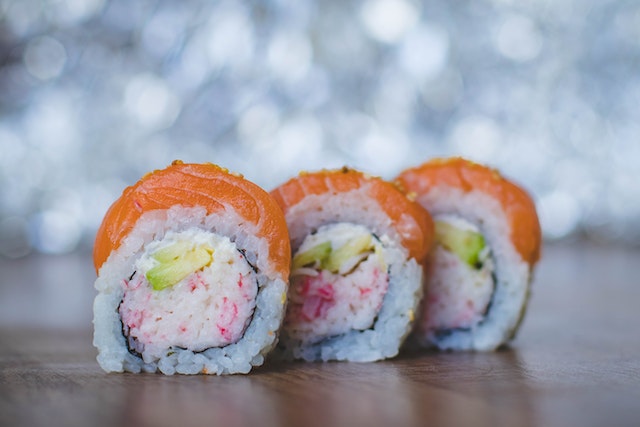 three sushi rolls displayed on a tray